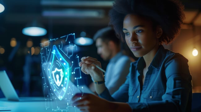 young-woman-dark-room-is-holding-tablet-displaying-glowing-cybersecurity-shield-symbol